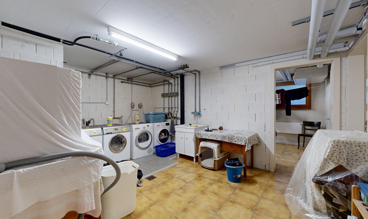 laundry area with washing machine and clothes dryer, concrete block wall, and cabinet space