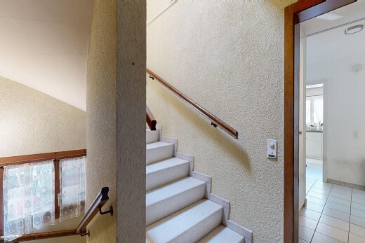 staircase featuring a textured wall and tile patterned floors