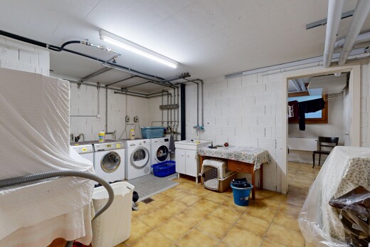 laundry area with washing machine and clothes dryer, concrete block wall, and cabinet space
