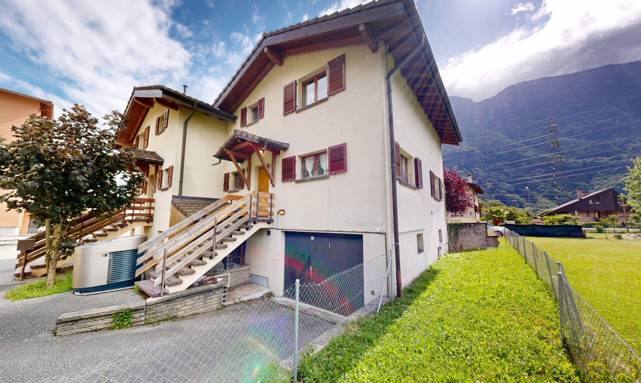 façade avec perron, garage intégré, bardage en stuc, pelouse, et property visible