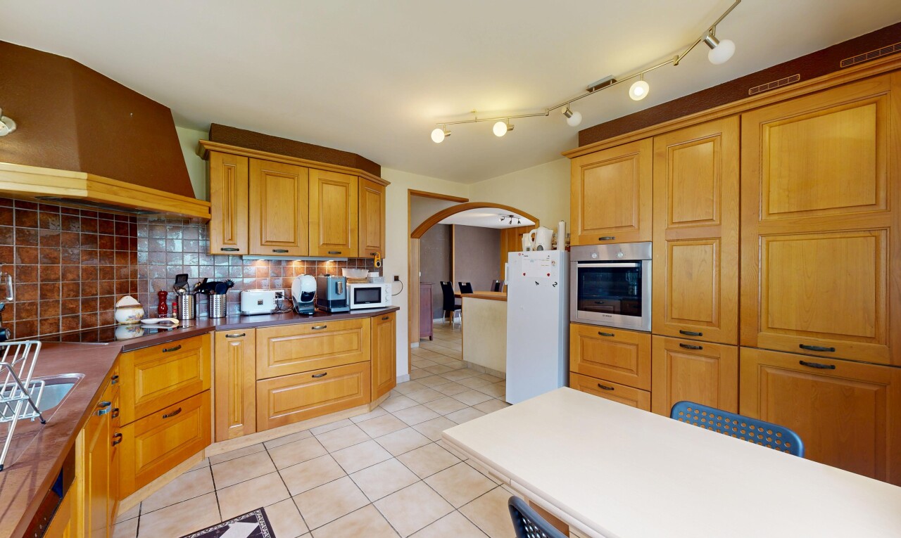 cuisine avec light floor, hotte, armoires avec moulures, crown molding cabinets, et armoires élevées