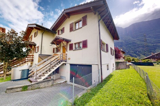 façade avec perron, garage intégré, bardage en stuc, pelouse, et property visible