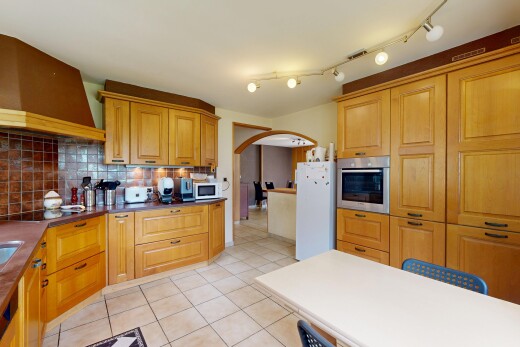 cuisine avec light floor, hotte, armoires avec moulures, crown molding cabinets, et armoires élevées