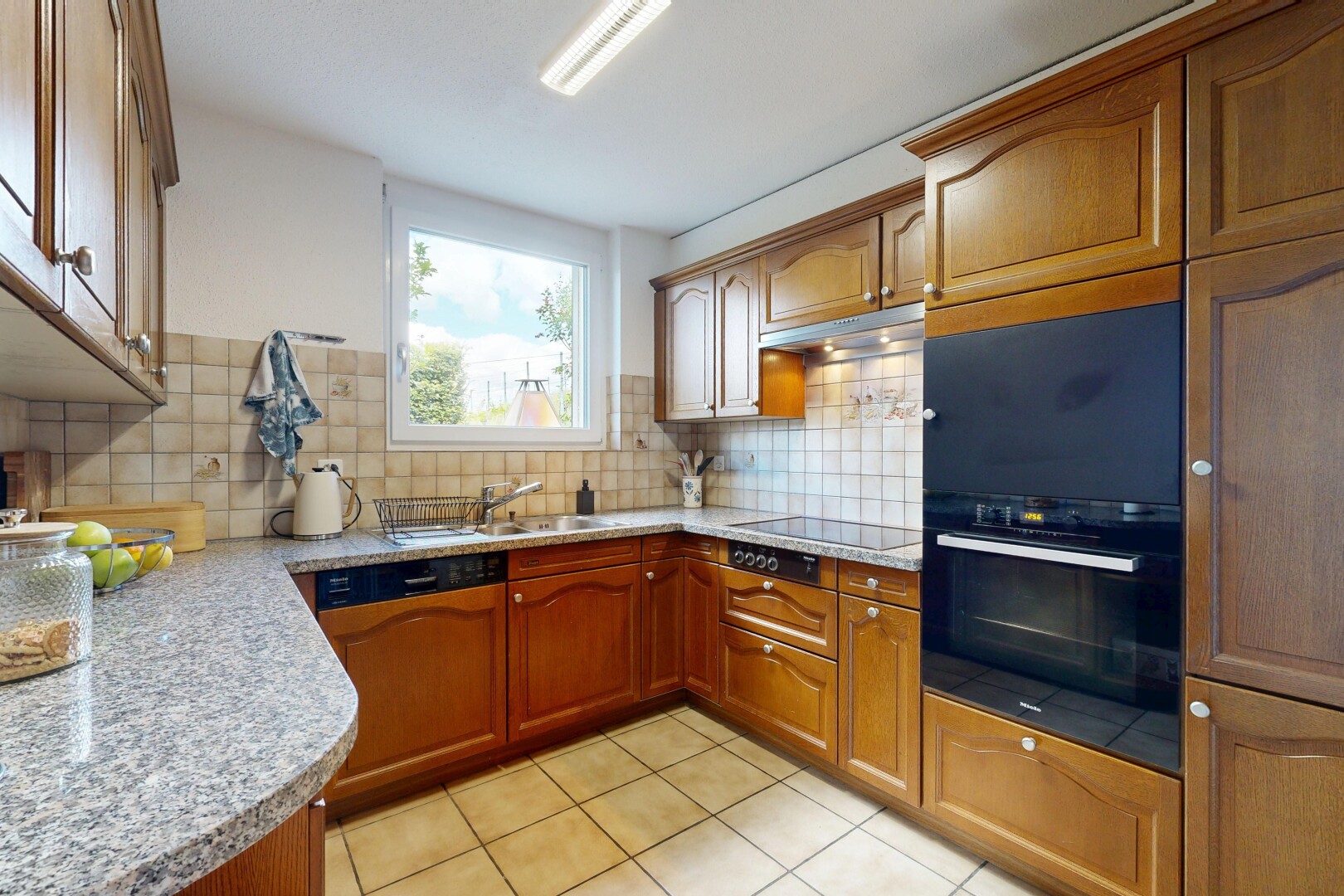 cuisine avec armoires en arc, arched cabinets, light floor, light countertops, et armoires avec moulures