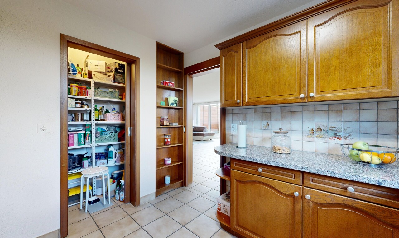 cuisine avec arched cabinets, armoires en arc, light countertops, medium brown cabinets, et armoires marron moyen