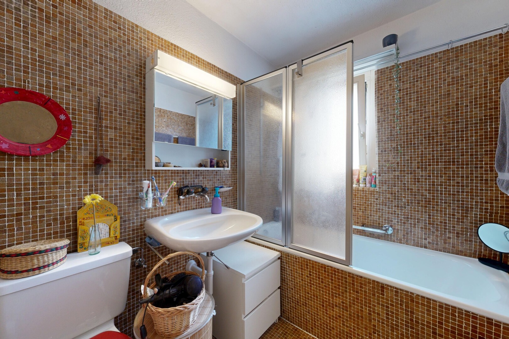 salle de bains avec mur en carrelage, tile wall, miroir, douche-bain combinés, et salle de bain complète
