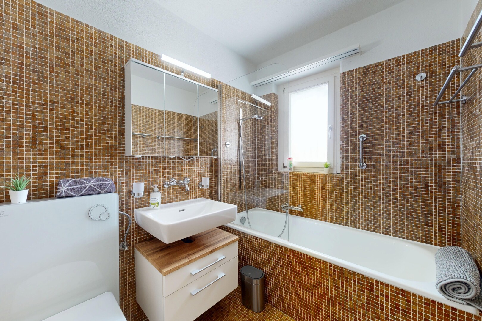 salle de bains avec tile wall, mur en carrelage, douche-bain combinés, toilette, et miroir