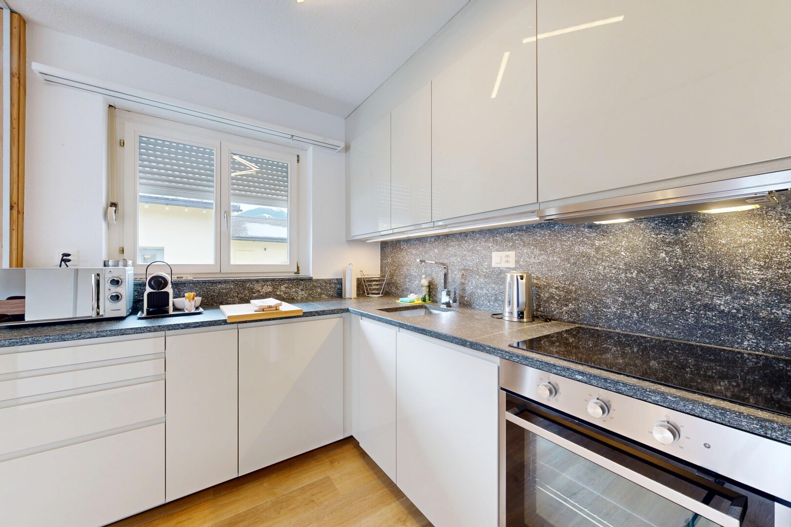cuisine avec four, dark countertops, armoires blanches, white cabinets, et light floor