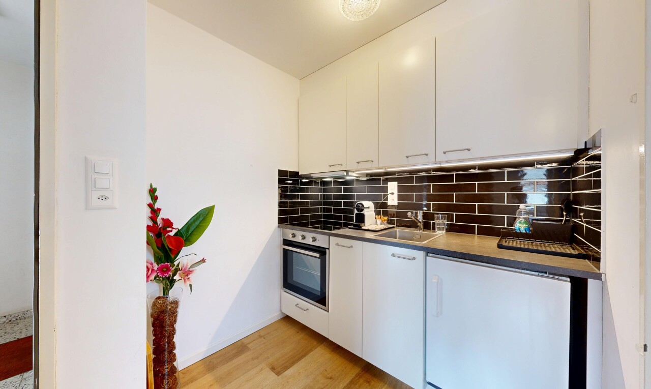 cuisine avec light floor, four, backsplash, dosseret, et armoires blanches