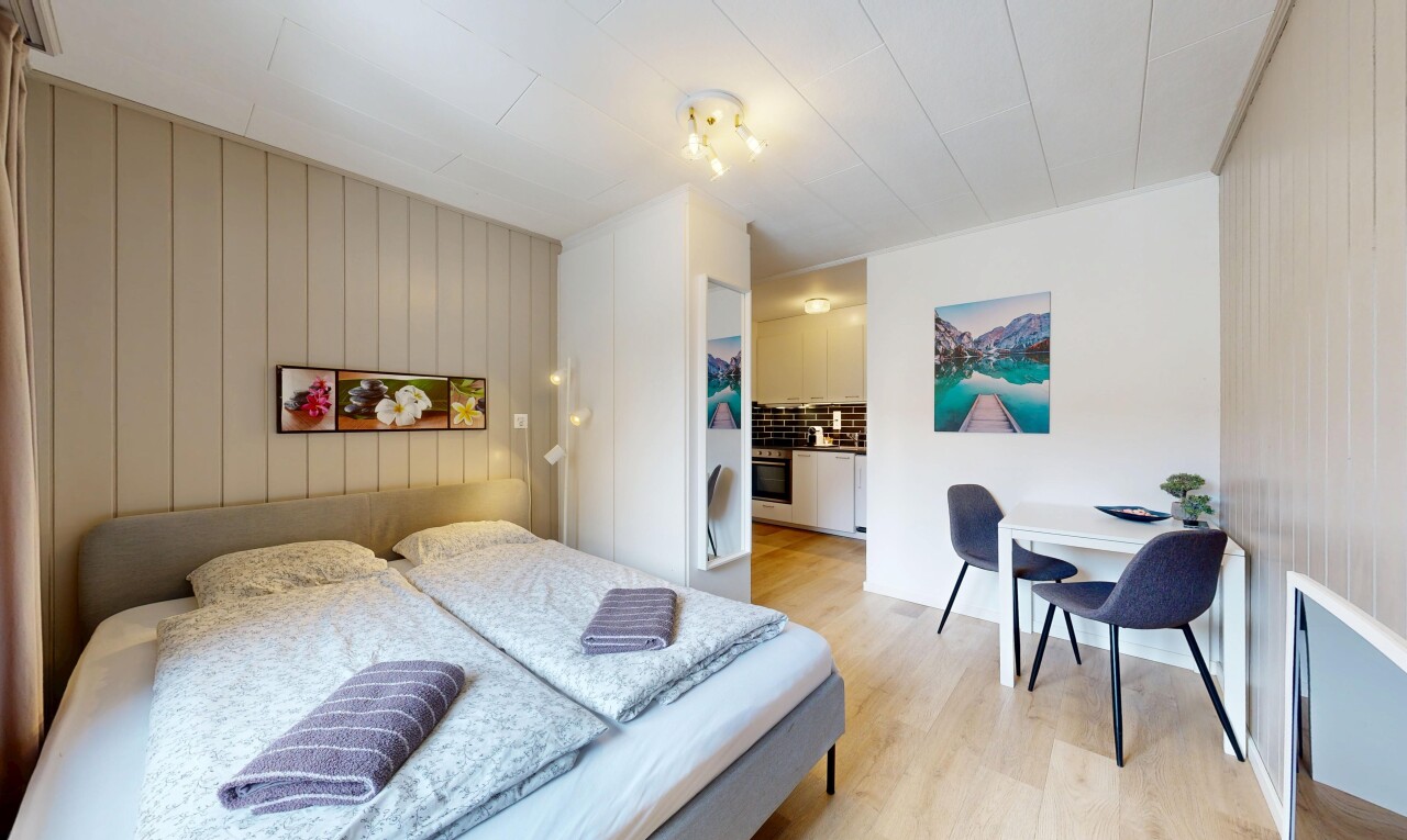 chambre avec sol en finition bois, wood finish floor, inside property, light floor, et salle de bain attenante
