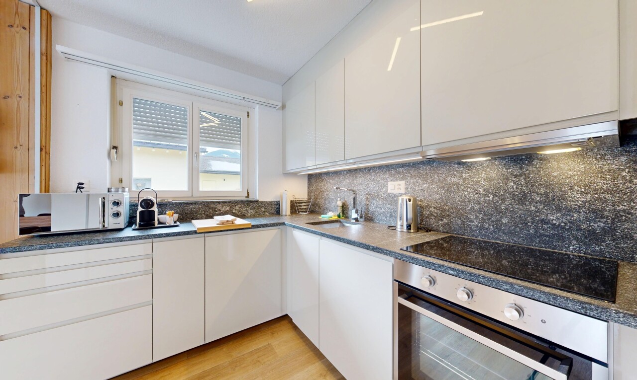 cuisine avec four, dark countertops, armoires blanches, white cabinets, et light floor
