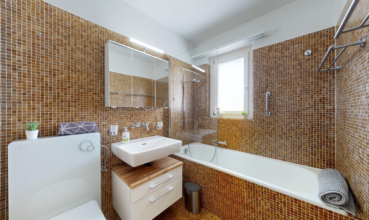 salle de bains avec tile wall, mur en carrelage, douche-bain combinés, toilette, et miroir
