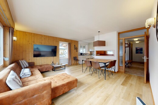wohn- / esszimmer mit fernseher, inside property, holzfußboden, wood finish floor, und holzwand