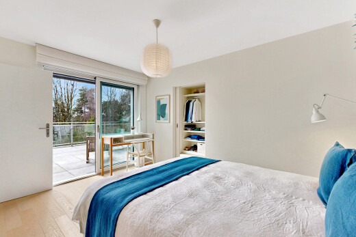 chambre avec lumière naturelle, accès à l'extérieur, cloison sèche, et sol en finition bois
