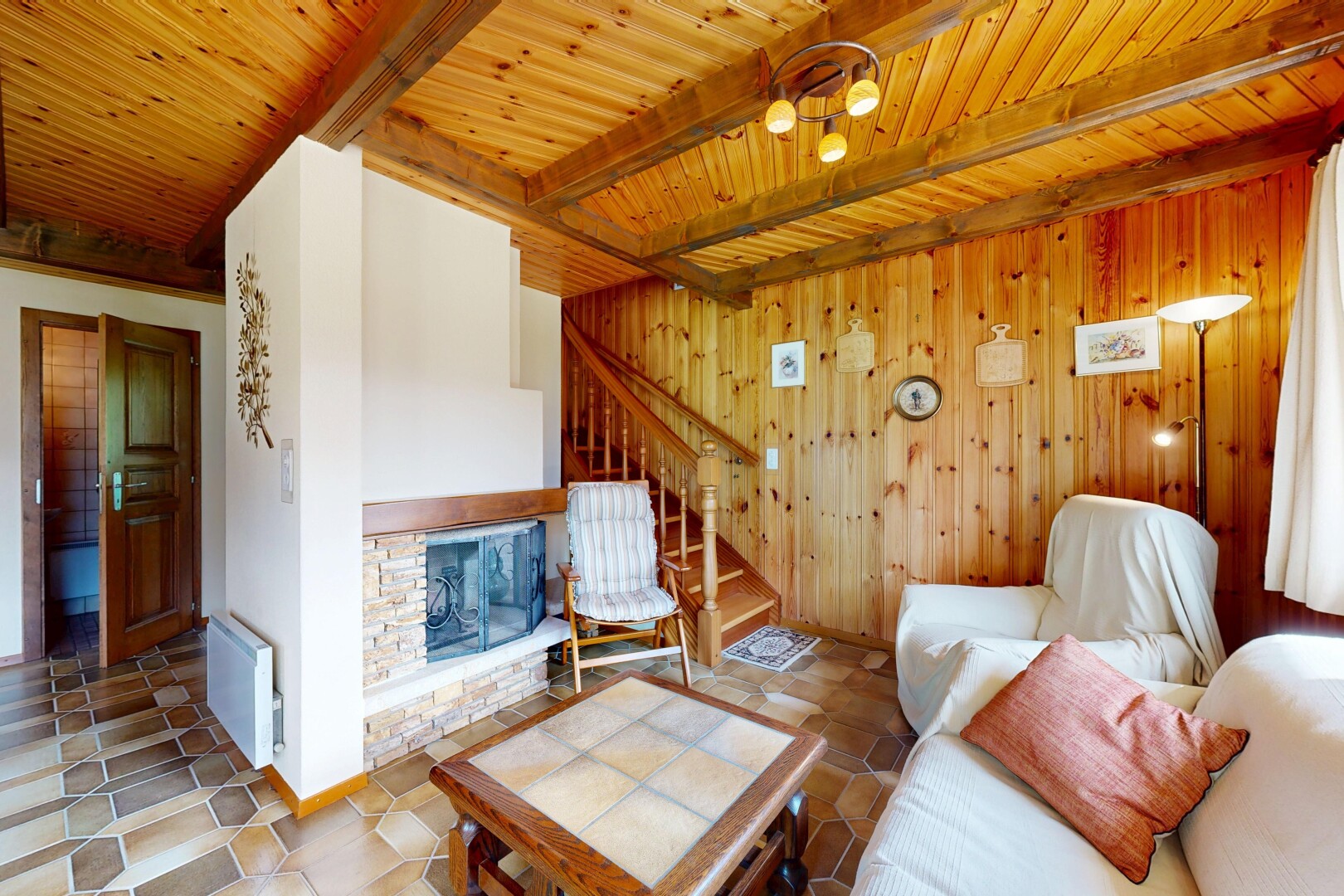 salon avec escaliers, cheminée, inside property, radiateur, et plafond à poutres