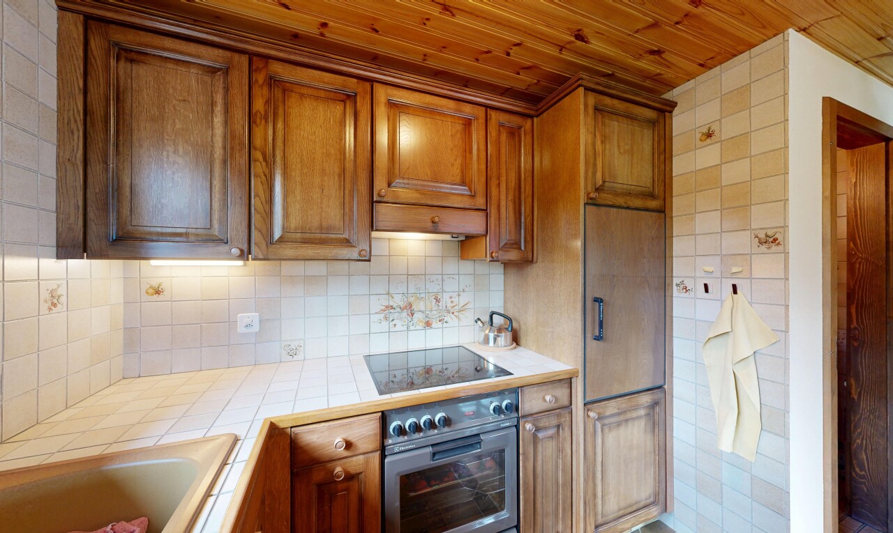 cuisine avec light countertops, plans de travail en carrelage, tile countertops, four, et armoires élevées