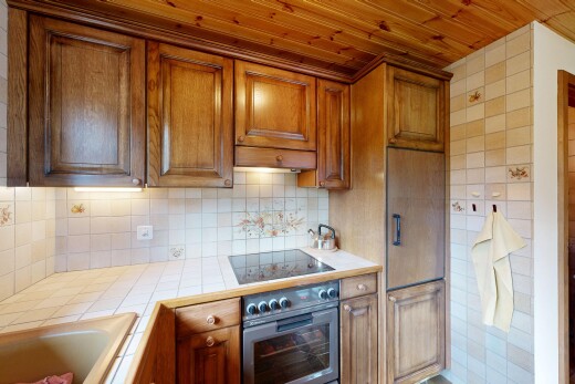 cuisine avec light countertops, plans de travail en carrelage, tile countertops, four, et armoires élevées