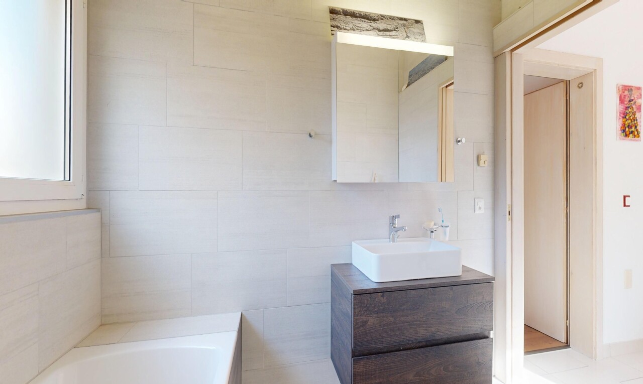 bad mit spiegel, inside property, schminktisch, waschbecken, und komplettes badezimmer
