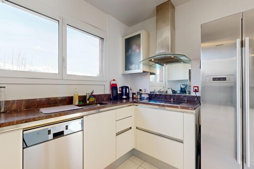 kitchen with stainless steel appliances, dark countertops, glass insert cabinets, light tile patterned flooring, and white cabinetry