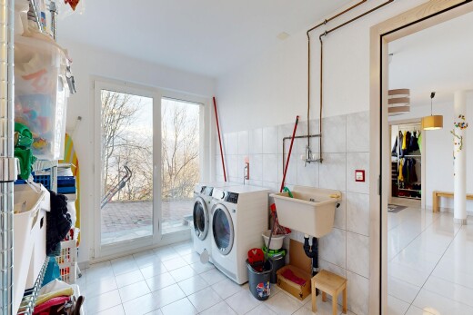 buanderie avec mur en carrelage, tile wall, lave-linge et sèche-linge séparés, sol en carrelage, et tile floor