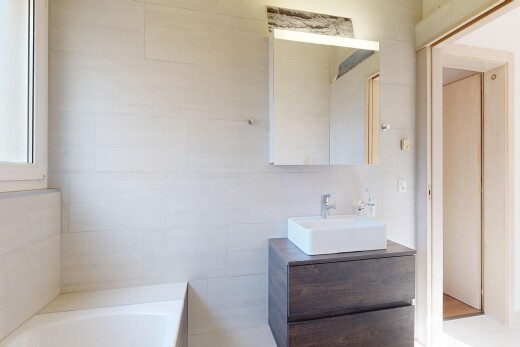 full bathroom with vanity, a bath, and tile walls