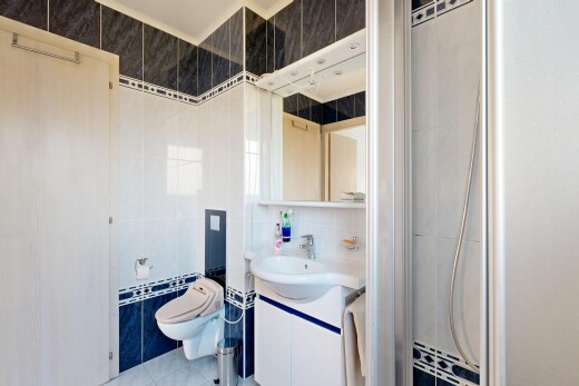 full bathroom with vanity, tile walls, a shower stall, and light tile patterned flooring