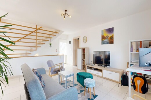 salon avec télévision, inside property, escaliers, cloison sèche, et drywall