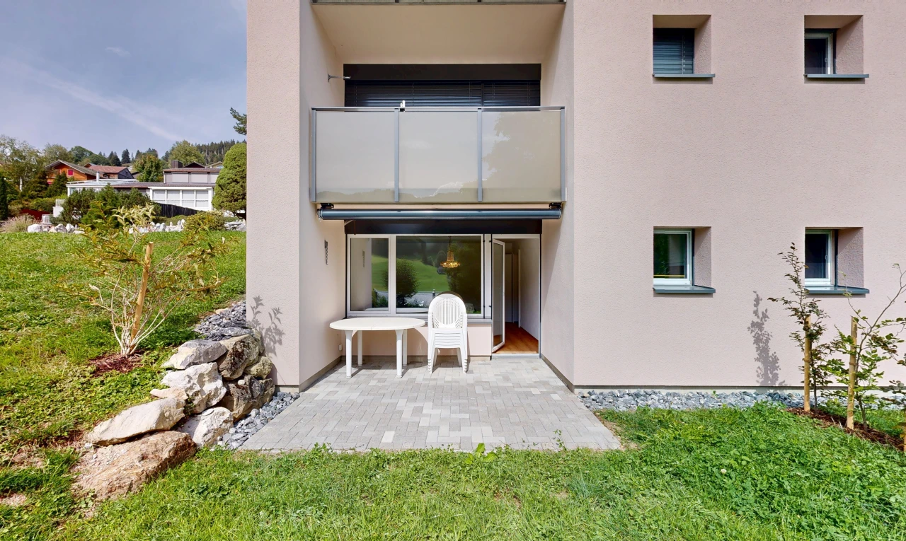 façade avec bardage en stuc et pelouse