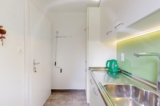 cuisine avec évier, white cabinets, armoires blanches, light floor, et inside property