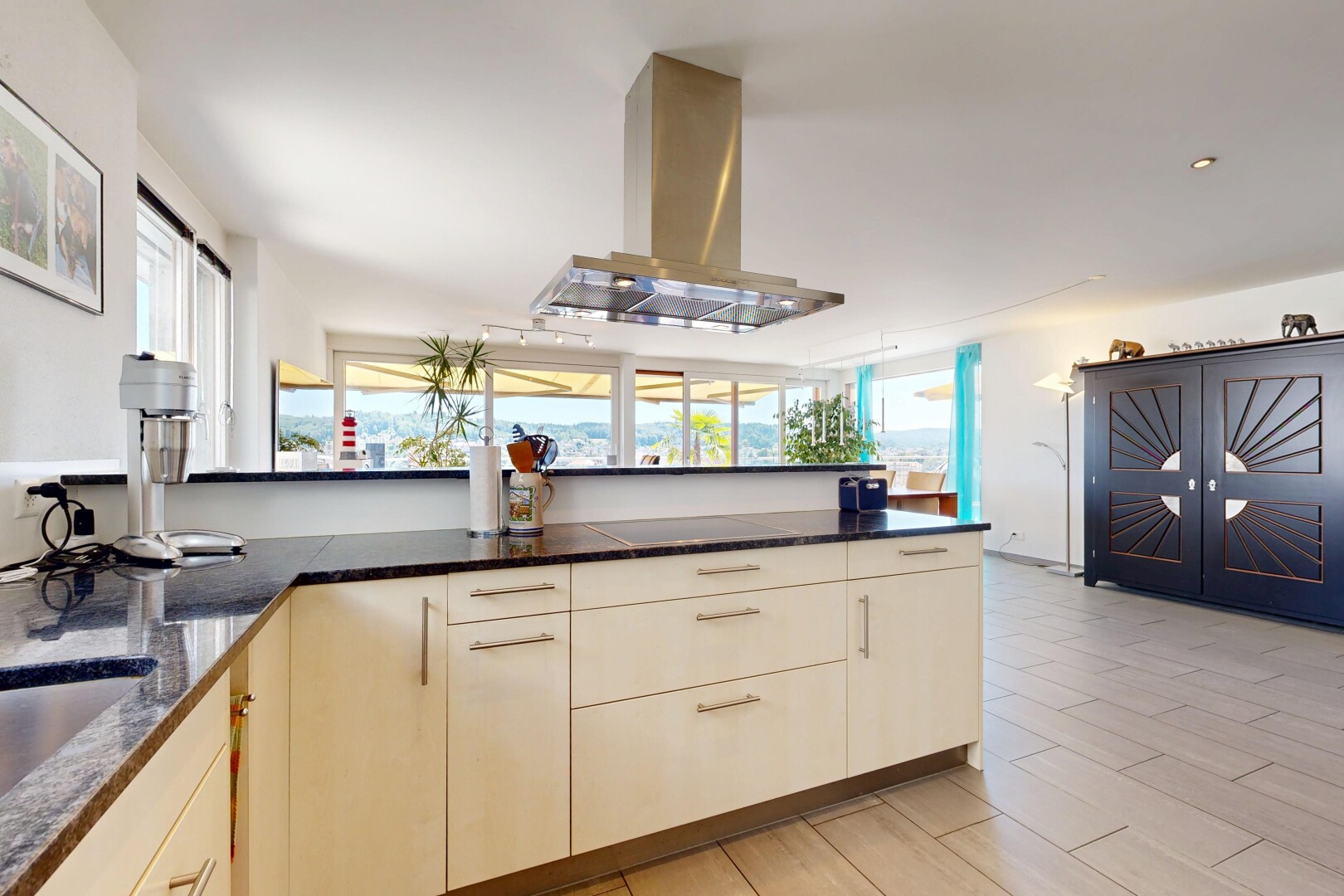 küche mit dark countertops, dunstabzugshaube, light floor, two heights countertops, und holzfußboden