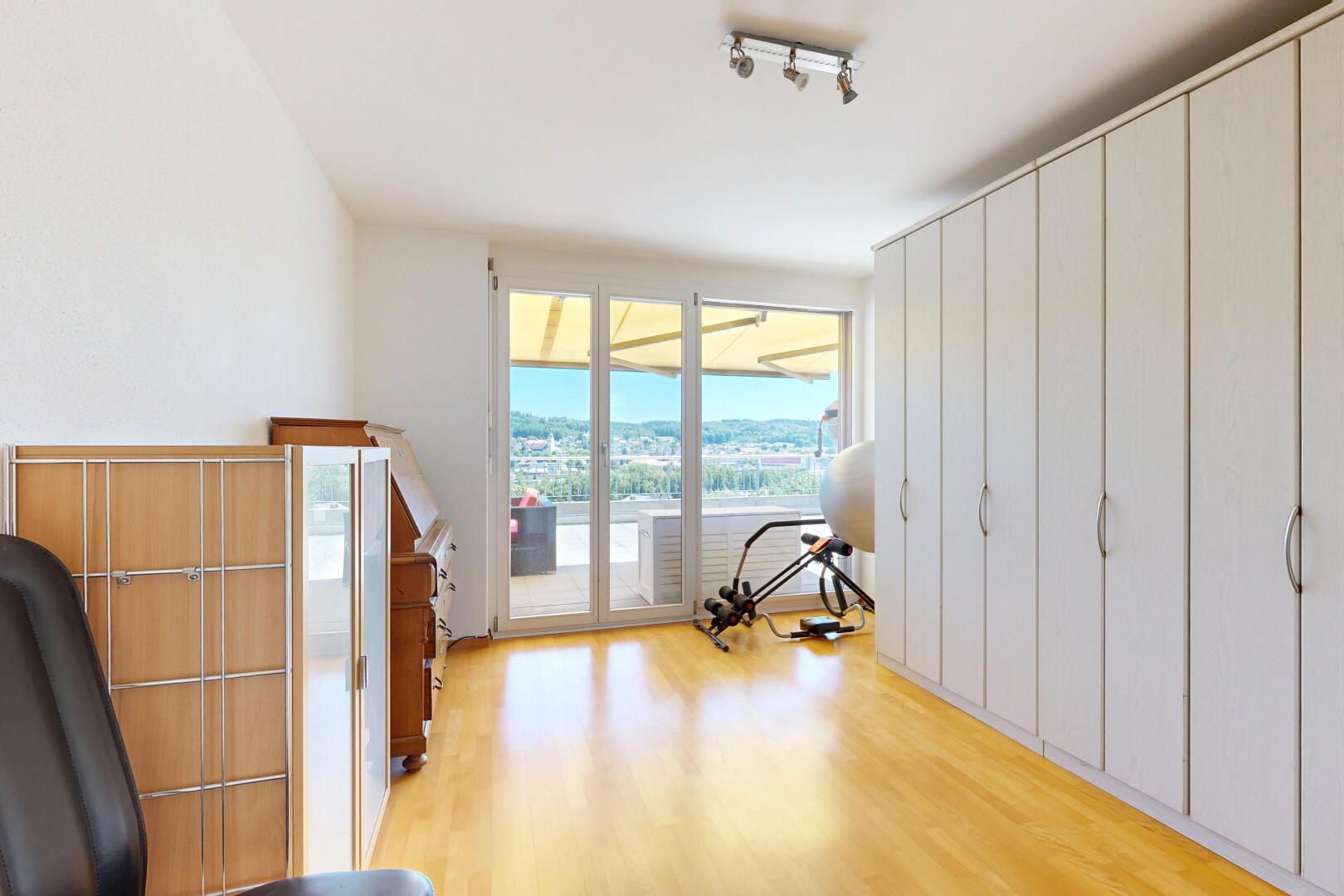 zimmer / schlafzimmer mit deckenbeleuchtung, außenzugang, wood finish floor, holzfußboden, und inside property
