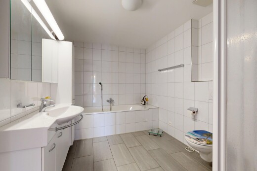 salle de bains avec tile wall, mur en carrelage, salle de bain complète, toilette, et bain