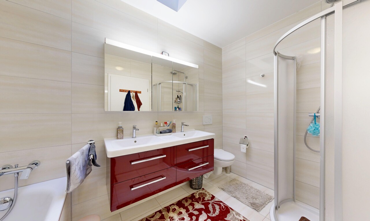 salle de bains avec salle de bain complète, tile wall, mur en carrelage, toilette, et double vasque