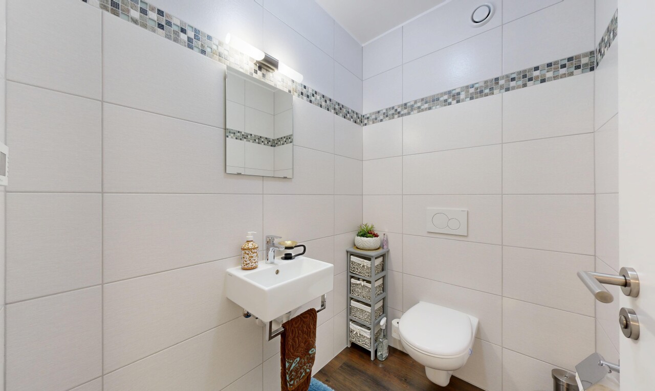 salle de bains avec miroir, inside property, virtually staged, toilette, et évier