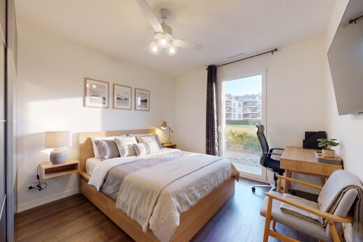 chambre avec télévision, ventilateur de plafond, drywall, cloison sèche, et wood finish floor