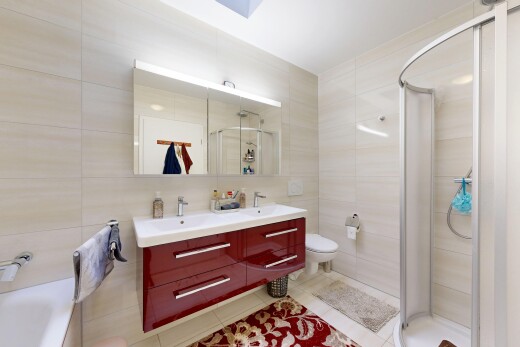 salle de bains avec salle de bain complète, tile wall, mur en carrelage, toilette, et double vasque