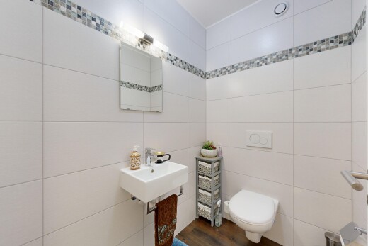 salle de bains avec miroir, inside property, virtually staged, toilette, et évier