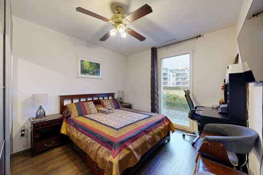 room / bedroom with access to outside, wood finished floors, a ceiling fan, and a desk