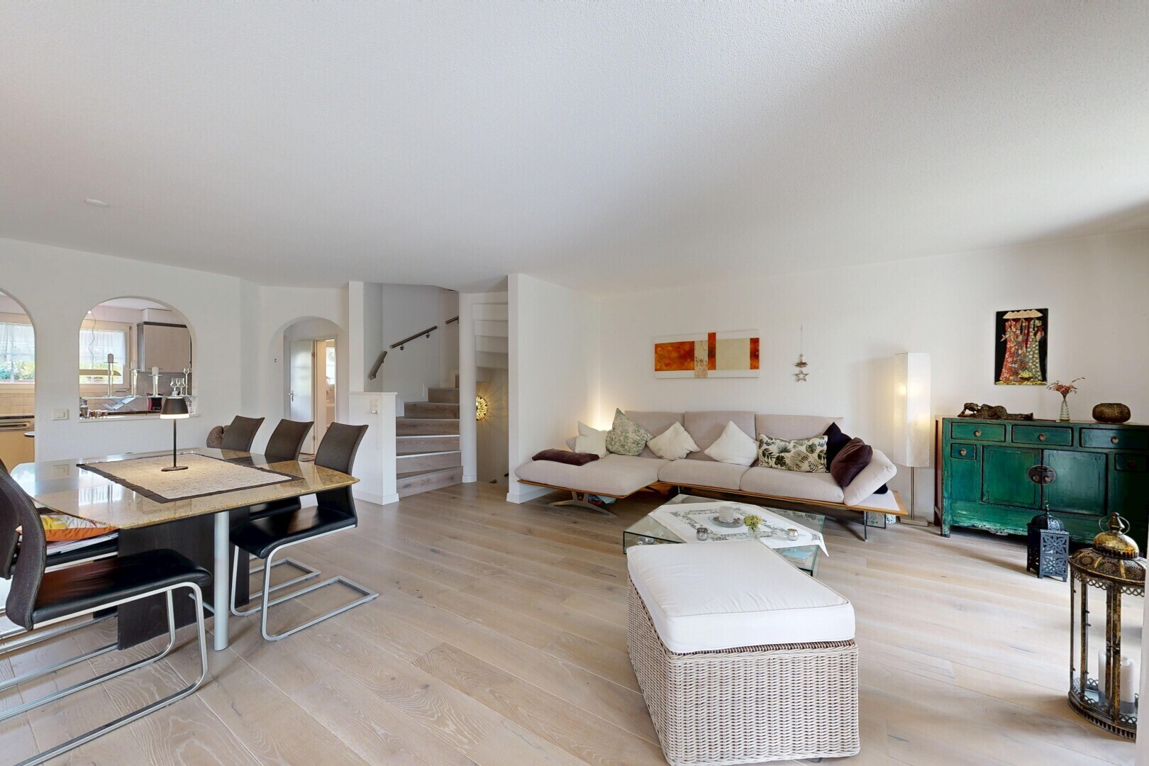 wohn- / esszimmer mit gewölbte gehwege, treppen, holzfußboden, wood finish floor, und gipskartonwand