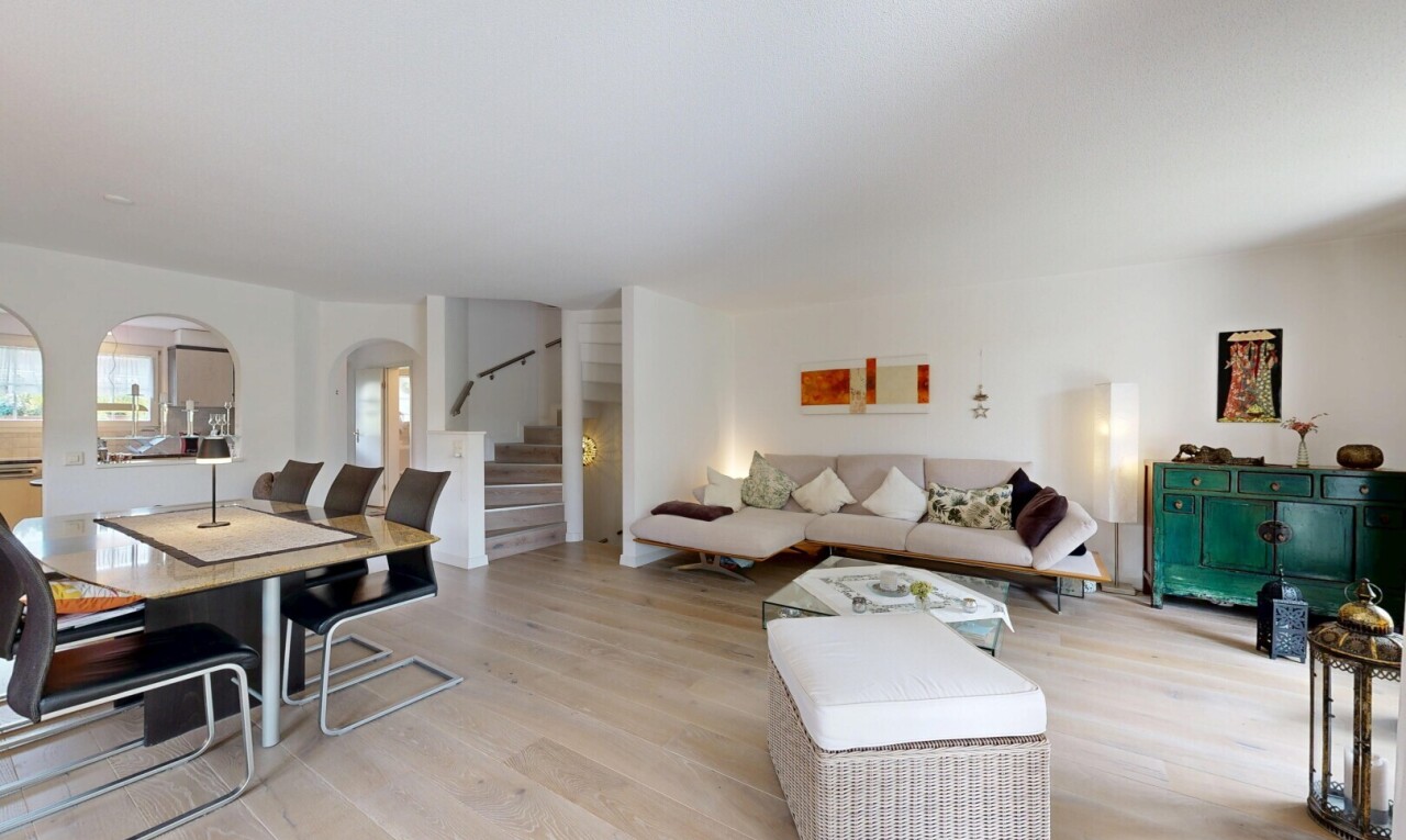 wohn- / esszimmer mit gewölbte gehwege, treppen, holzfußboden, wood finish floor, und gipskartonwand