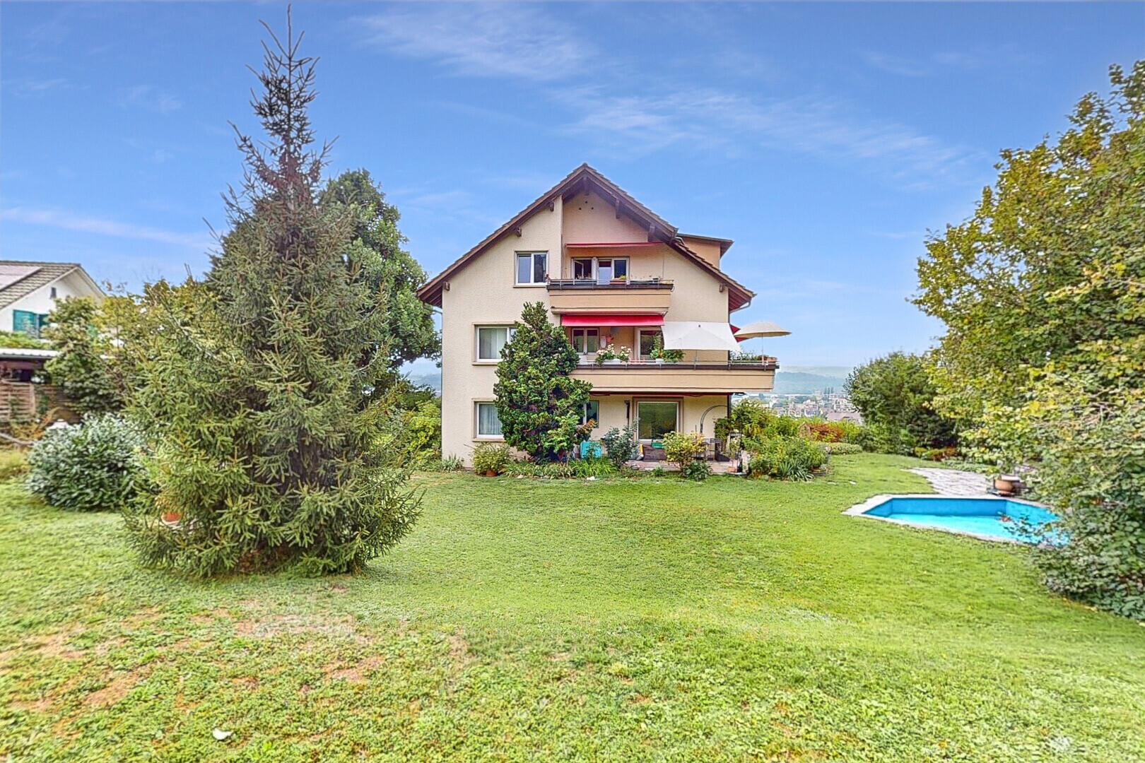 façade avec pelouse, balcon, day time, property visible, et bardage en stuc