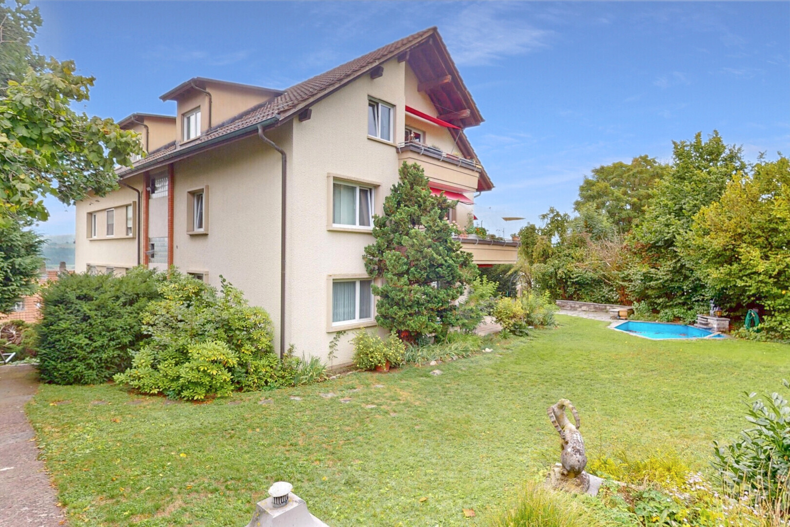 façade avec pelouse, property visible, bardage en stuc, et day time
