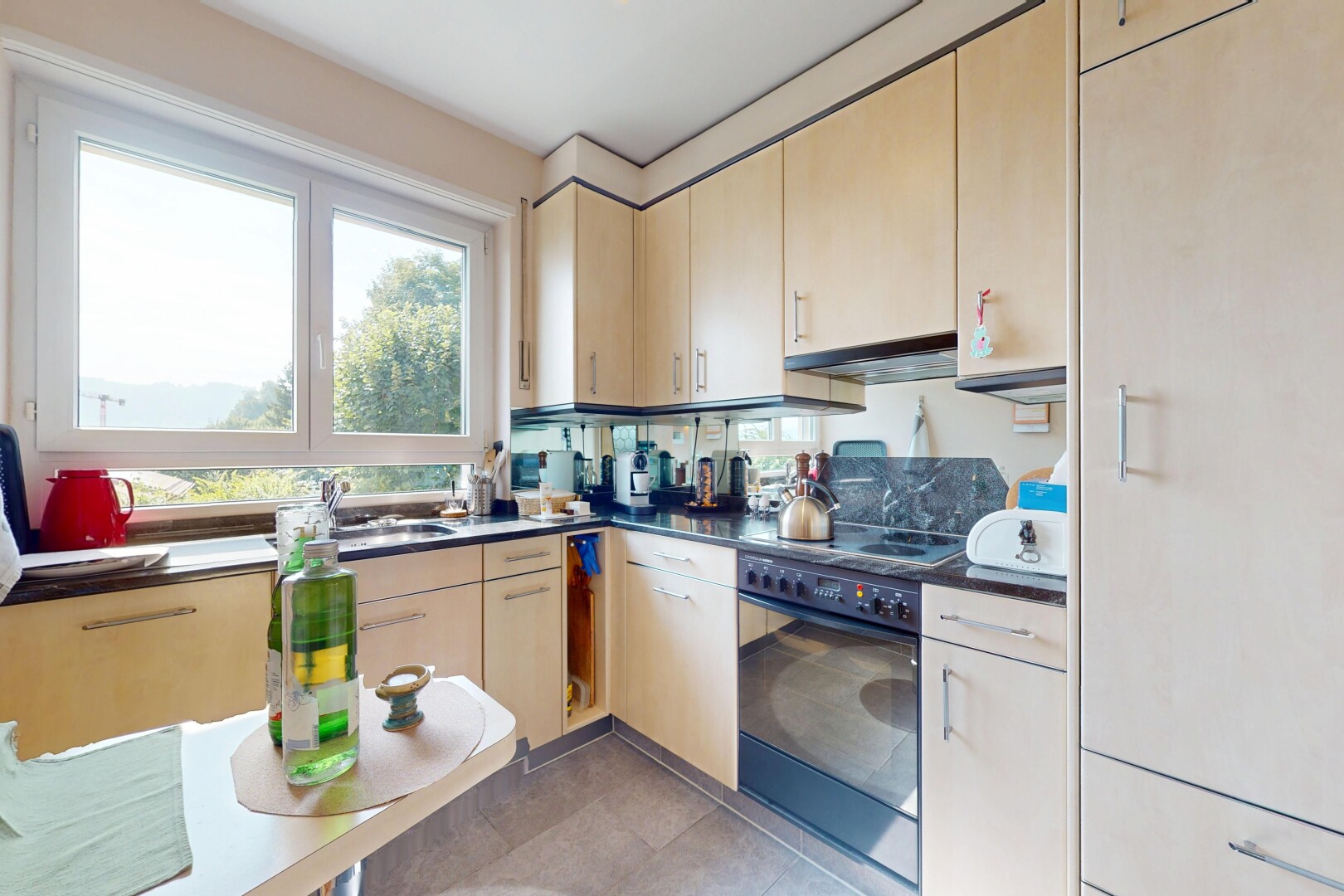 cuisine avec natural light, lumière naturelle, four, inside property, et plans de travail