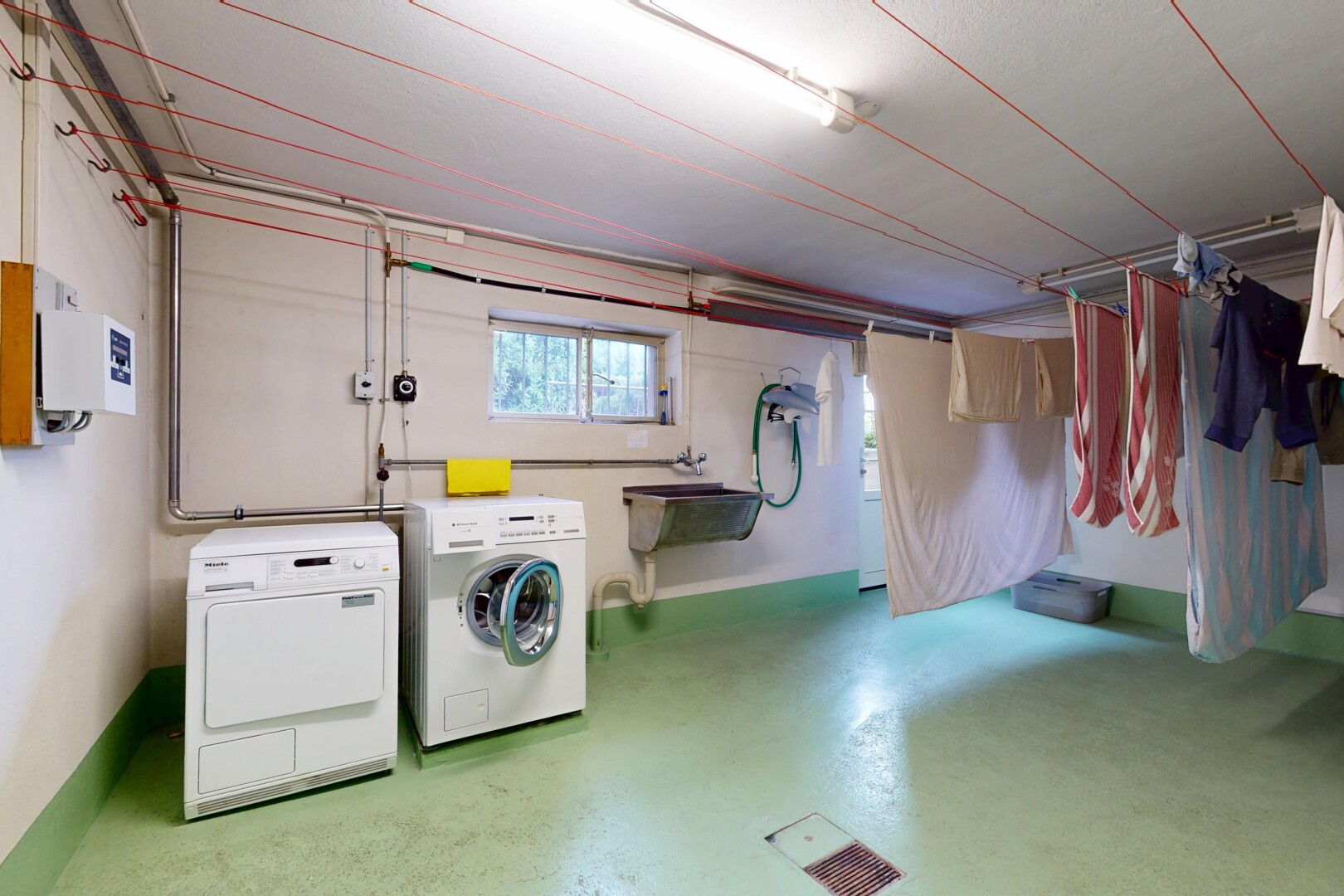 buanderie avec natural light, lumière naturelle, inside property, finished concrete floor, et concrete floor