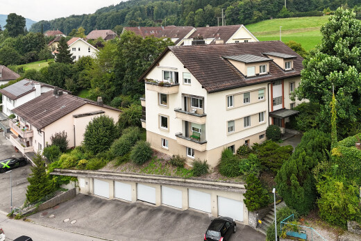 außenansicht mit stuckverkleidung, dachgaube, gemeinschaftsgaragen, und drone view