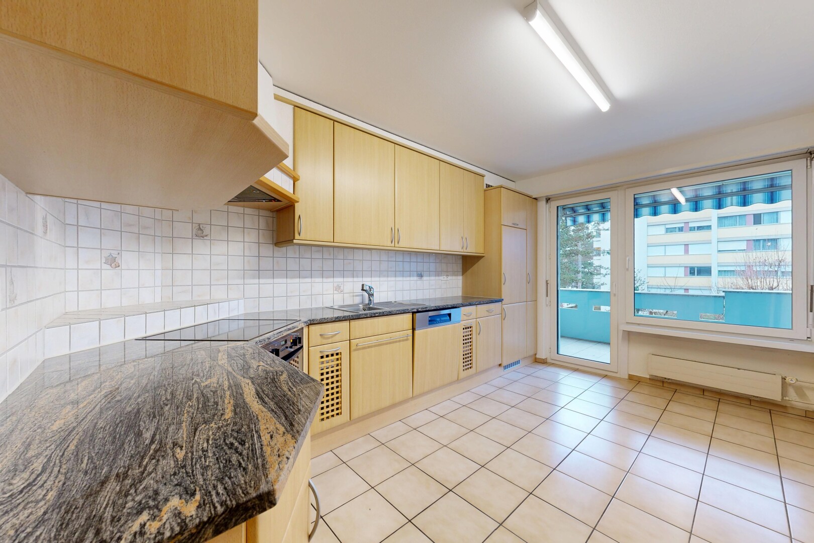 cuisine avec armoires marron clair, sol en carrelage, tile floor, dosseret, et backsplash