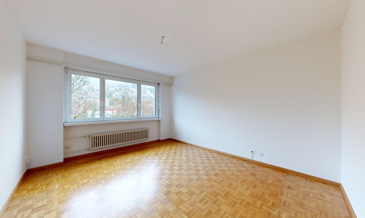 pièce vide avec parquet floor, cloison sèche, drywall, radiateur, et plinthes murales