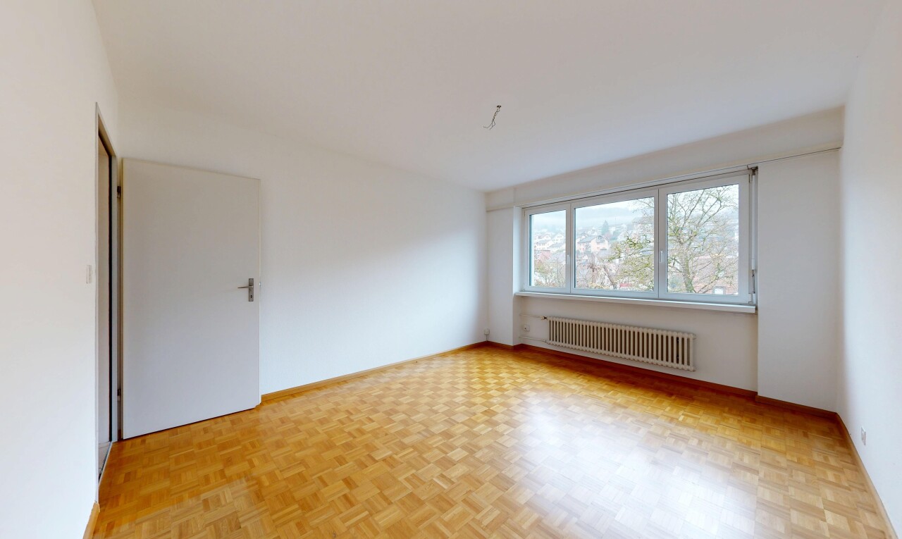 pièce vide avec parquet floor, cloison sèche, drywall, radiateur, et lumière naturelle