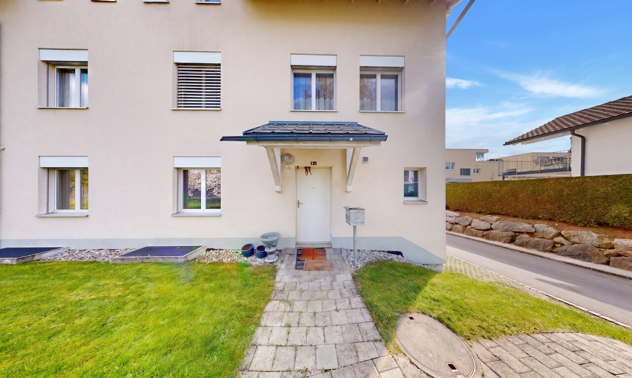 façade avec property visible, bardage en stuc, et pelouse