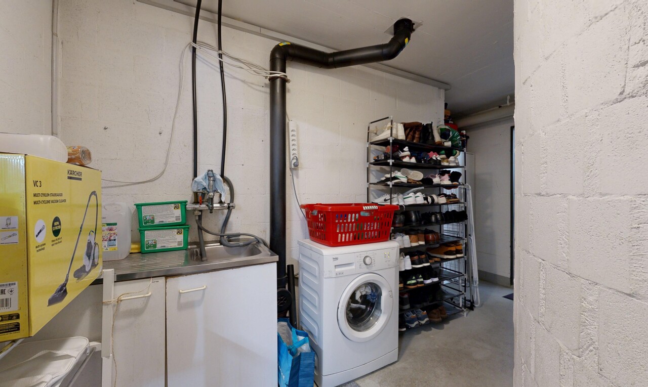 buanderie avec lave-linge et sèche-linge, concrete floor, sol en béton, buanderie, et inside property